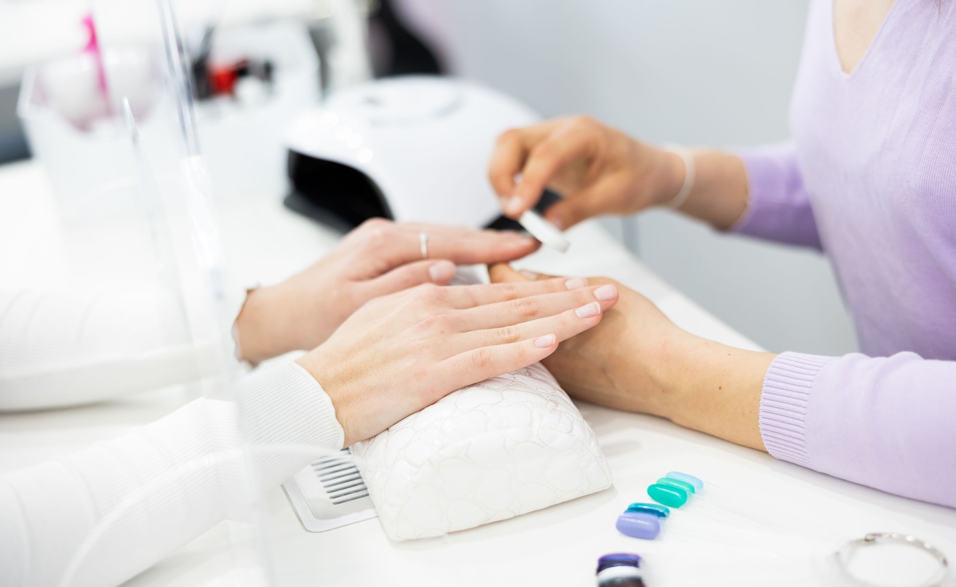 Woman hands, with which the manicure master files nails