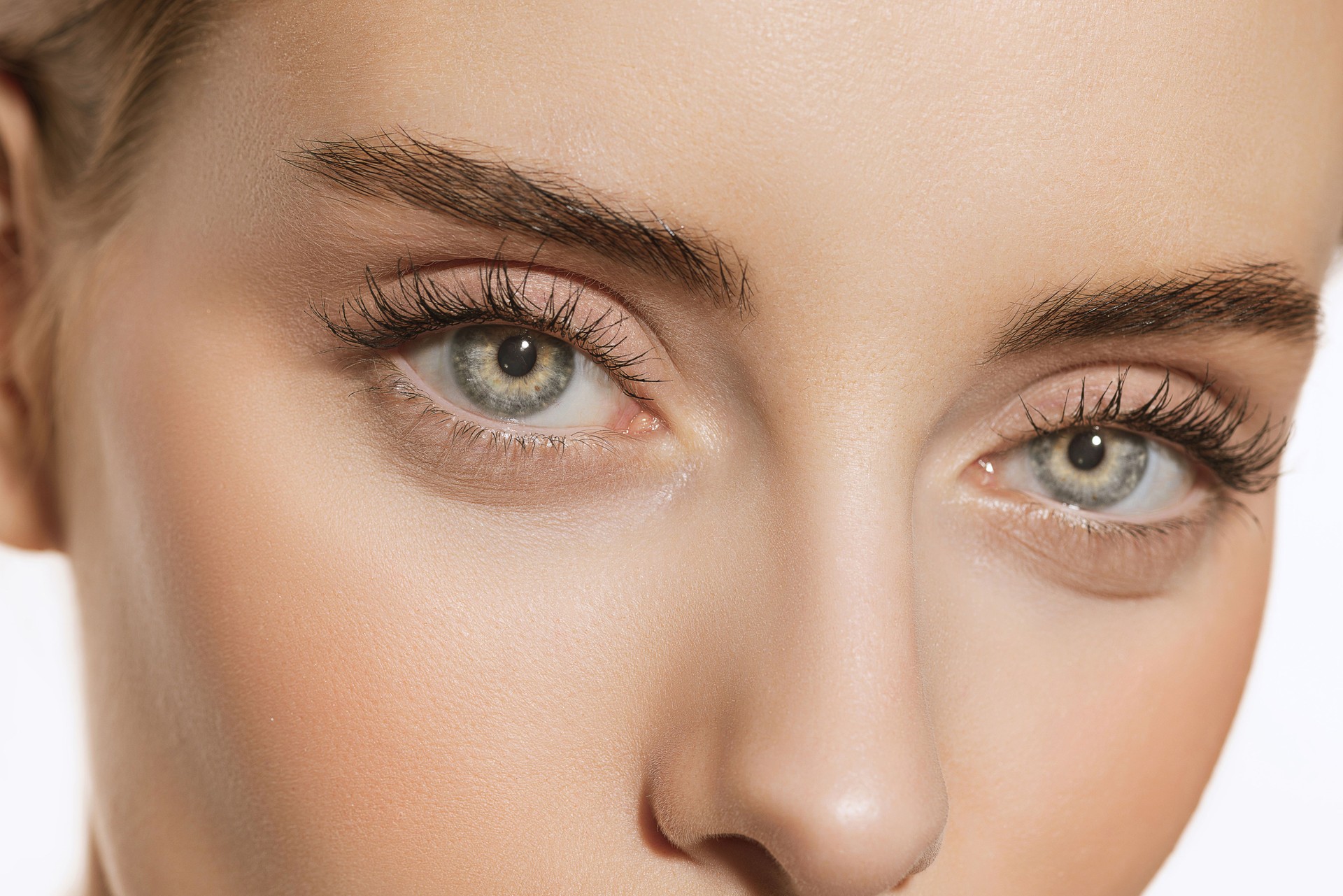 Blue eyes and perfect shapes of eyebrows. Close up portrait of beautiful young girl looking at camera. Concept of cosmetics, makeup, eco treatment, skin care.